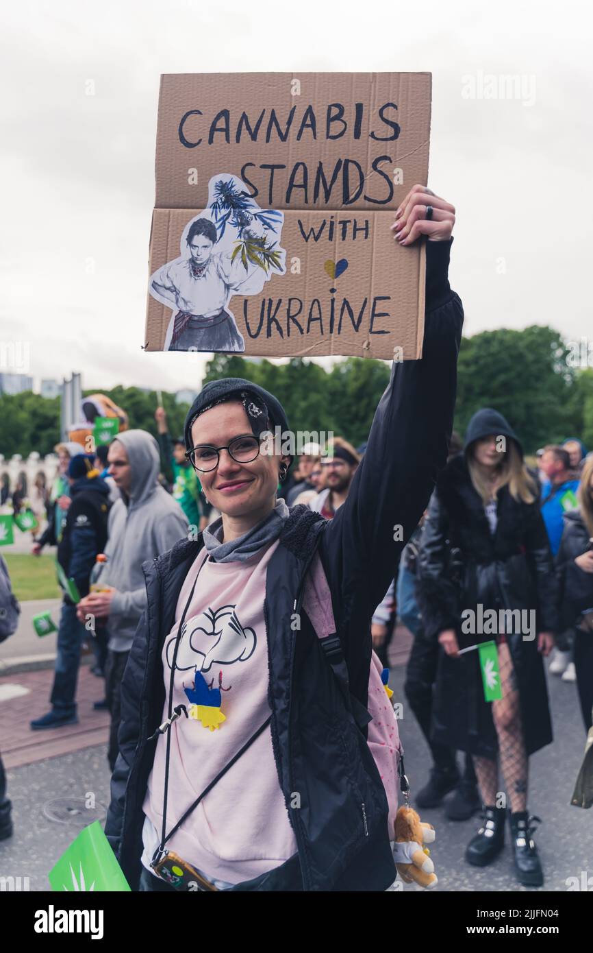 05.28.2022 Varsavia, Polonia. Colpo verticale all'aperto di un manifestante caucasico che lotta per la marijuana legale e che tiene un cartellone che dice - cannabis sta con l'Ucraina. Foto di alta qualità Foto Stock