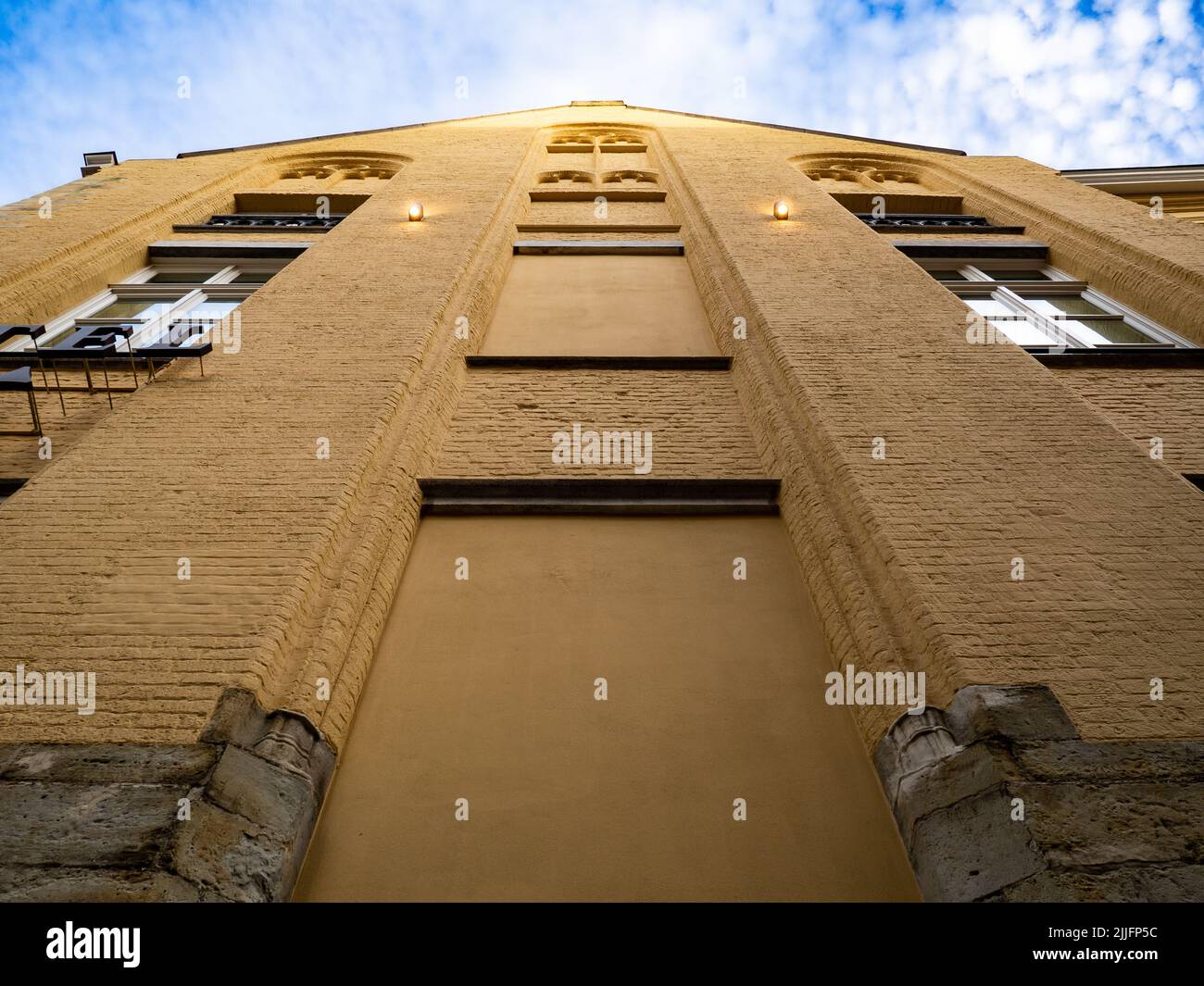 Foto dal basso di un vecchio edificio giallo nella città di Bruges. Foto Stock