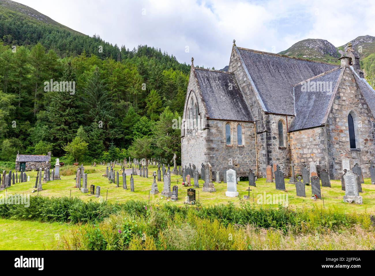 Chiesa episcopale di San Giovanni a Ballachulish ai piedi di Glen Coe nelle Highlands scozzesi, Scozia, Regno Unito, con pietre sepolte nel cimitero Foto Stock