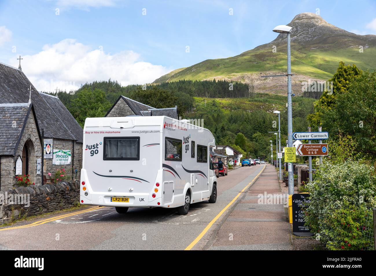 Motorhome sulla strada nel villaggio di Glencoe, pap di glencoe visibile, estate 2022, Scozia, Regno Unito, Europa Foto Stock