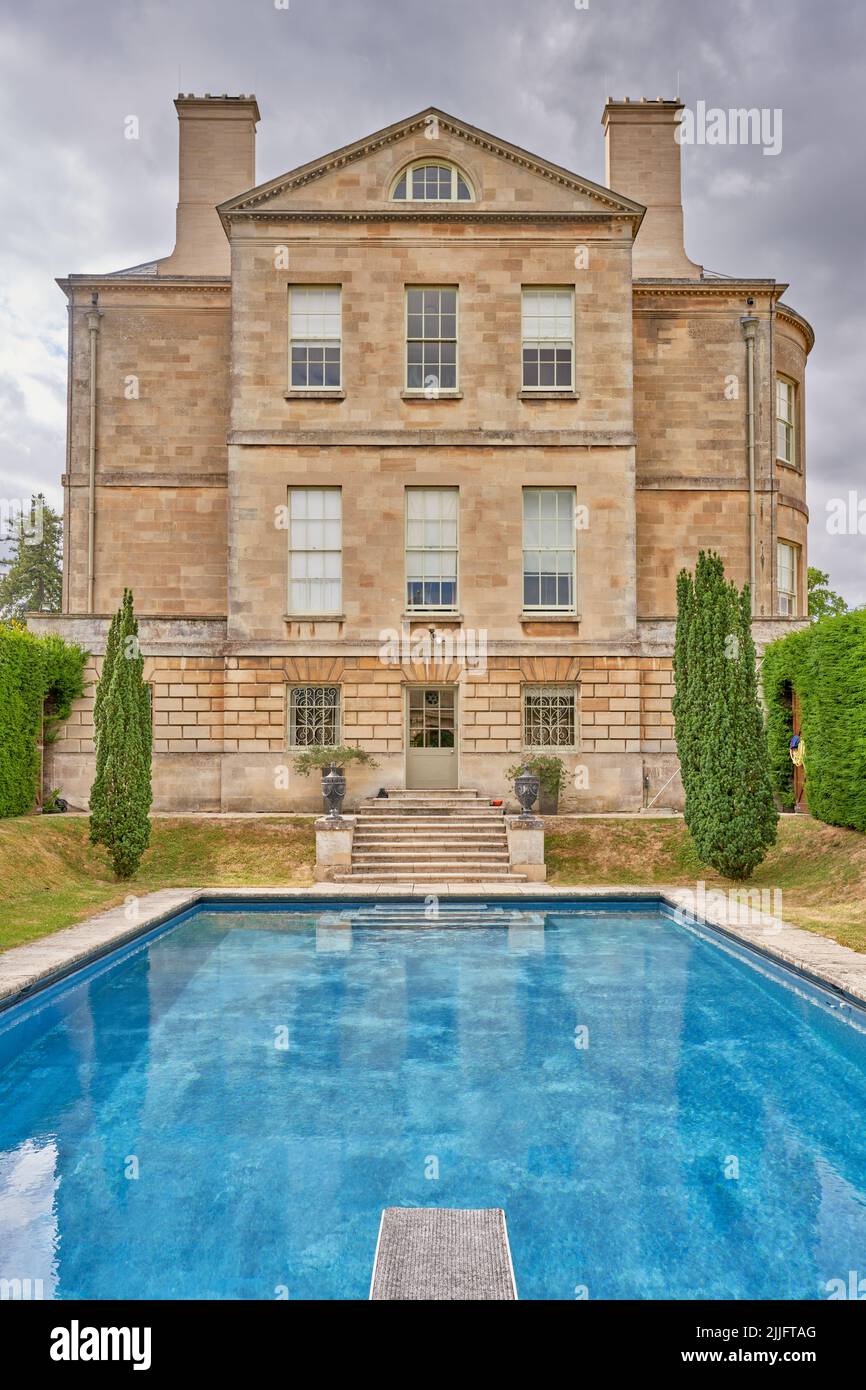 Piscina all'aperto accanto ad una tradizionale casa di campagna in pietra Foto Stock