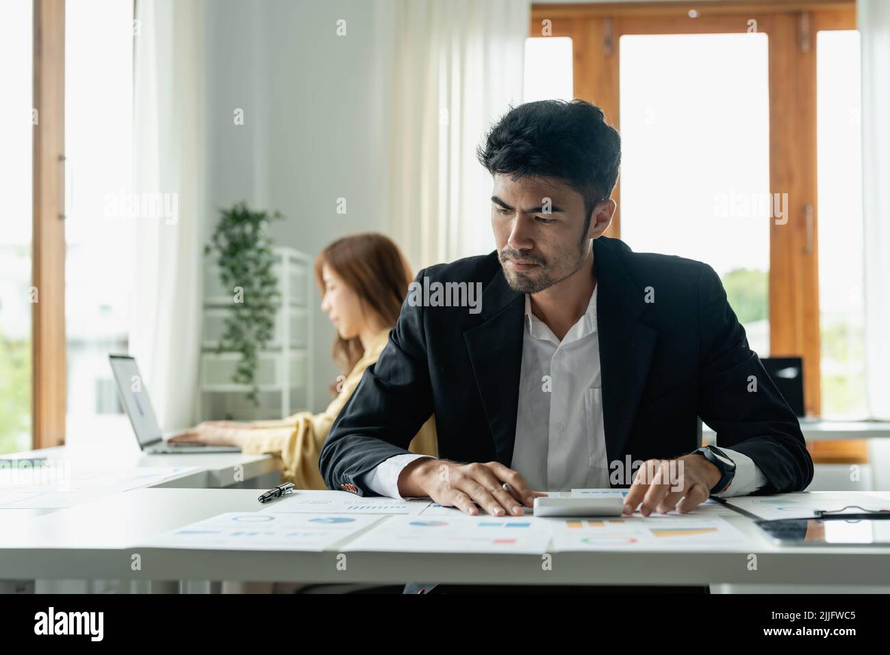 Uomo d'affari e partner che utilizzano la calcolatrice per calcolare il concetto di finanza, imposta, contabilità, statistiche e ricerca analitica Foto Stock