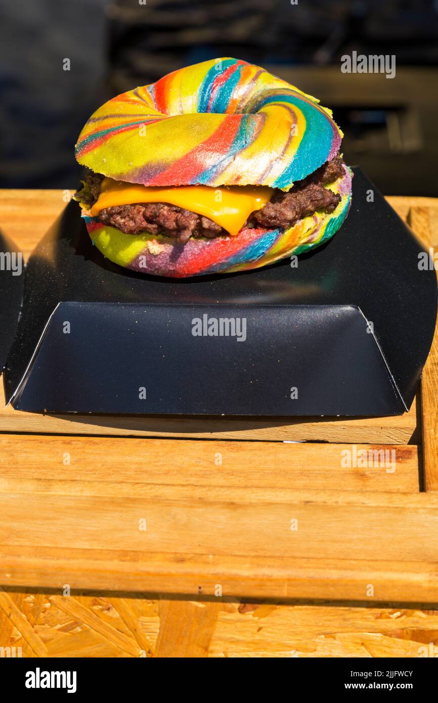 Unicorn Burger Hampshire bistecca sminuzzata rainbow bagel glitterato per la vendita di cibo stalla all'evento a Poole, Dorset Regno Unito nel mese di luglio Foto Stock