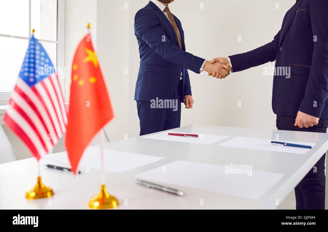 Stretta di mano dei politici cinesi e americani dopo la conclusione di un accordo commerciale. Foto Stock