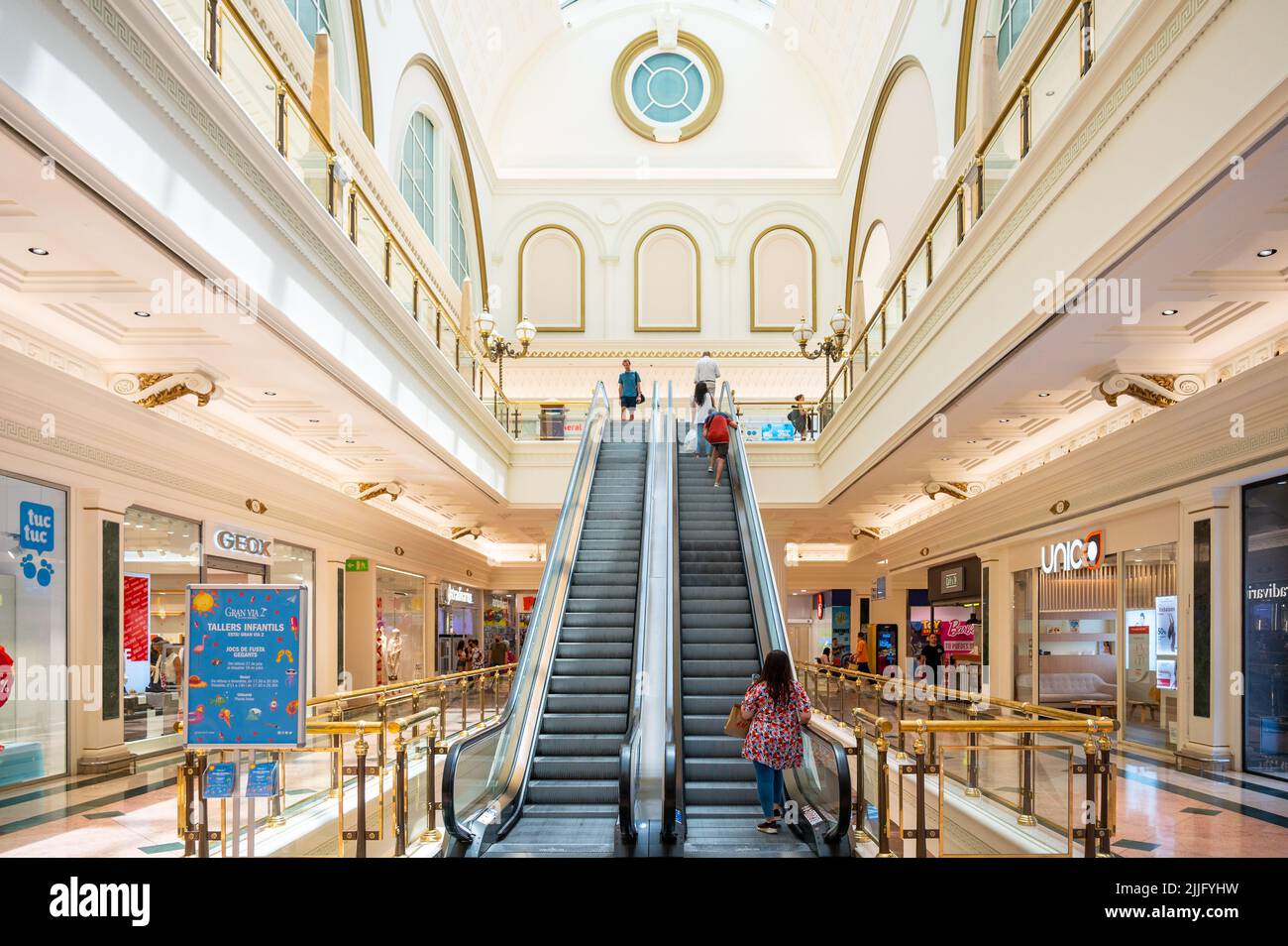 Persone in una scala mobile all'interno del centro commerciale Gran Via 2. Foto Stock