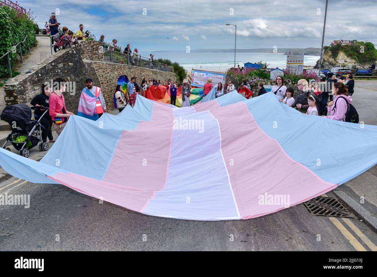 La bandiera di Pride Transgender tenuta dai partecipanti alla Cornovaglia è premiata dalla parata di Pride nel centro di Newquay nel Regno Unito. Foto Stock