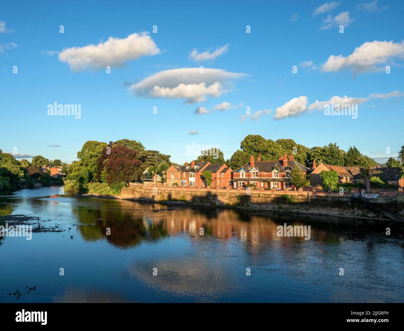 Edifici illuminati dal sole lungo la riva del fiume Wye in una serata estiva Hereford Herefordshire Inghilterra Foto Stock