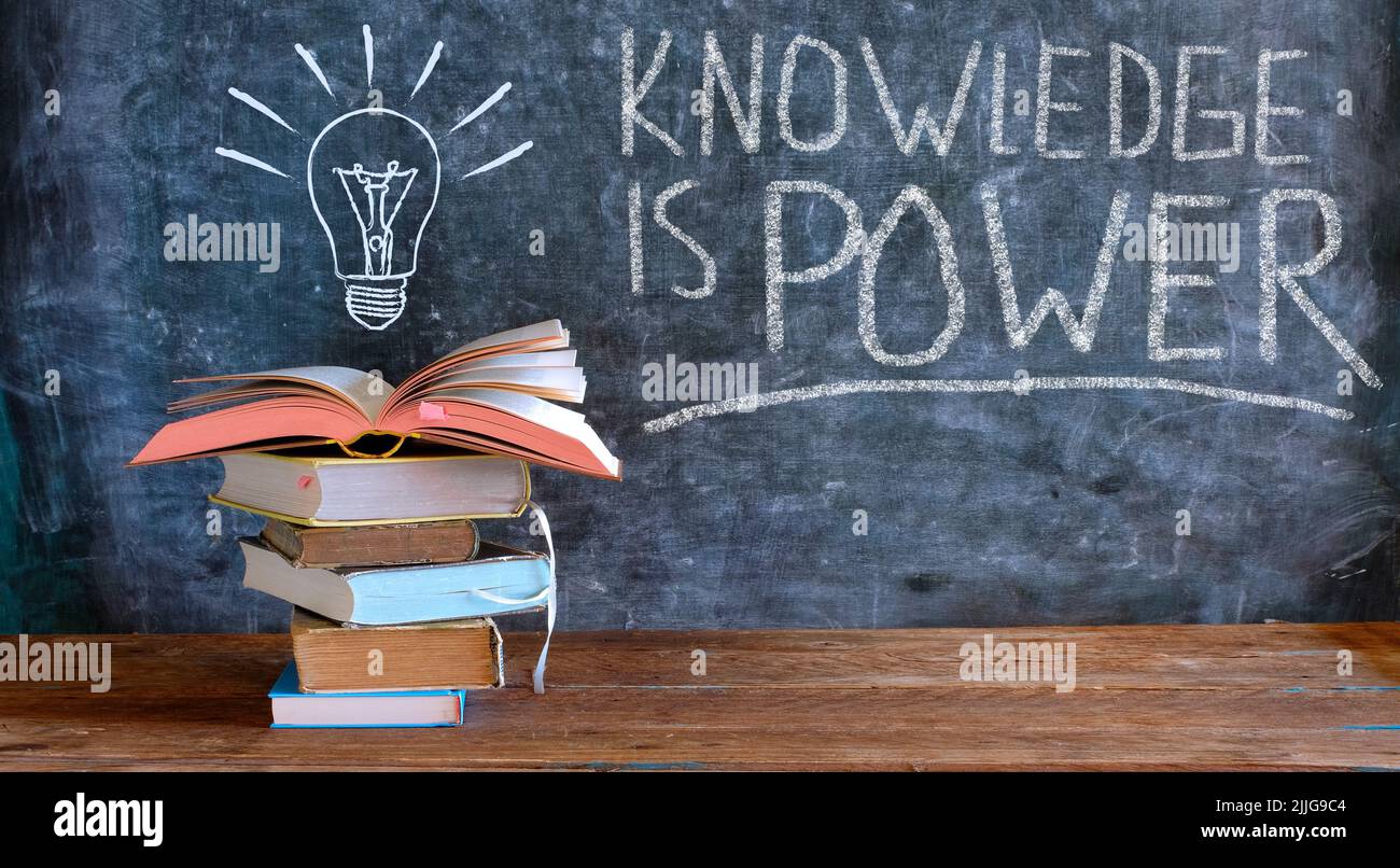 La conoscenza è potere, libri e lavagna con disegno di una lampadina, istruzione, apprendimento, lettura, idea, conoscenza Foto Stock