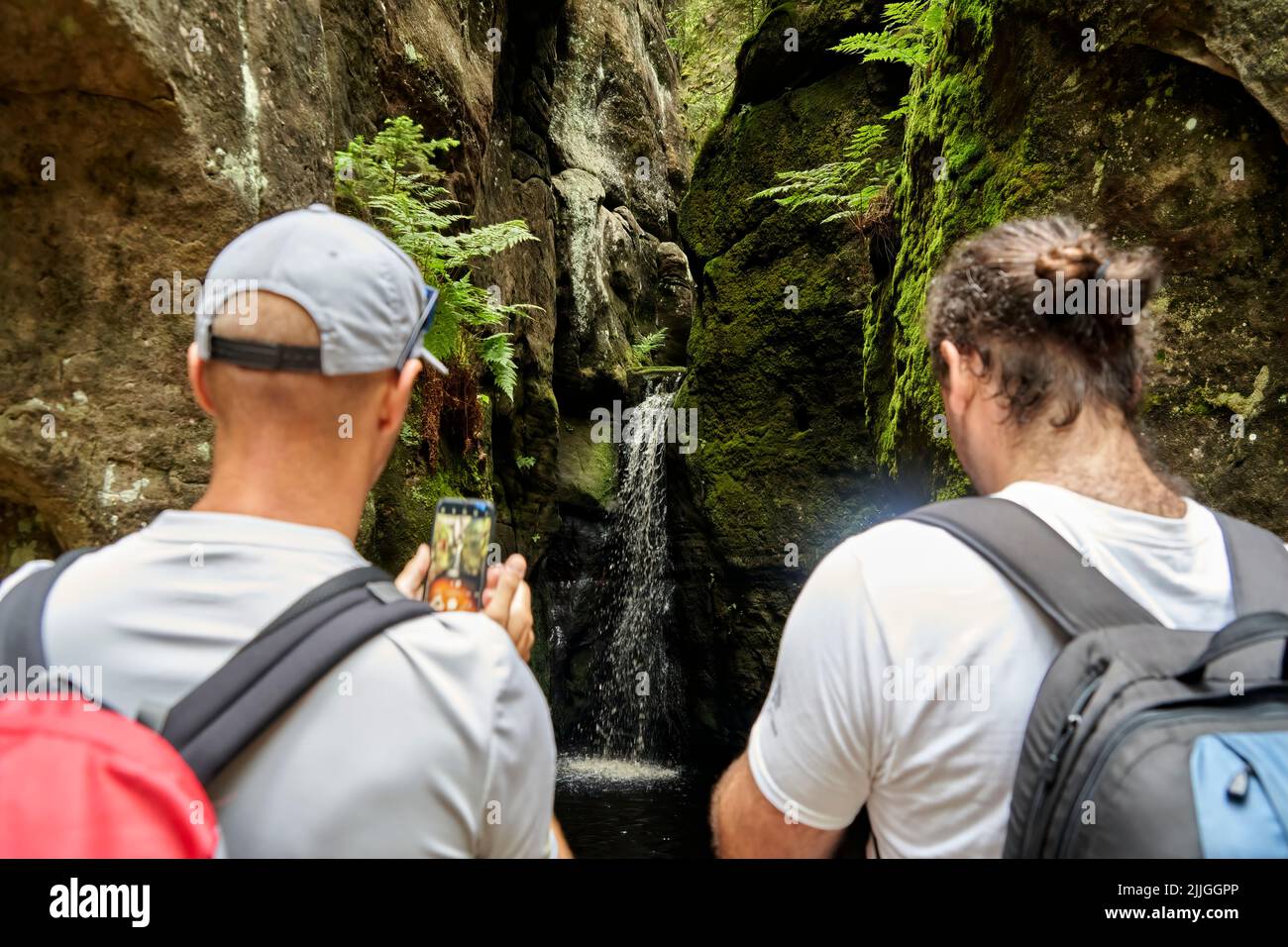 Adersbach, Repubblica Ceca, 4 luglio 2022: Piccola cascata nelle montagne di Krkonoše fotografata dai turisti con telefoni cellulari Foto Stock