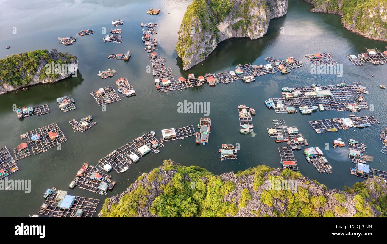 Villaggio galleggiante di pescatori e isola rocciosa nella baia di ' LAN ha ', Vietnam, Asia sud-orientale. Sito patrimonio dell'umanità dell'UNESCO. Orizzontale. Punto di riferimento popolare, famoso d Foto Stock