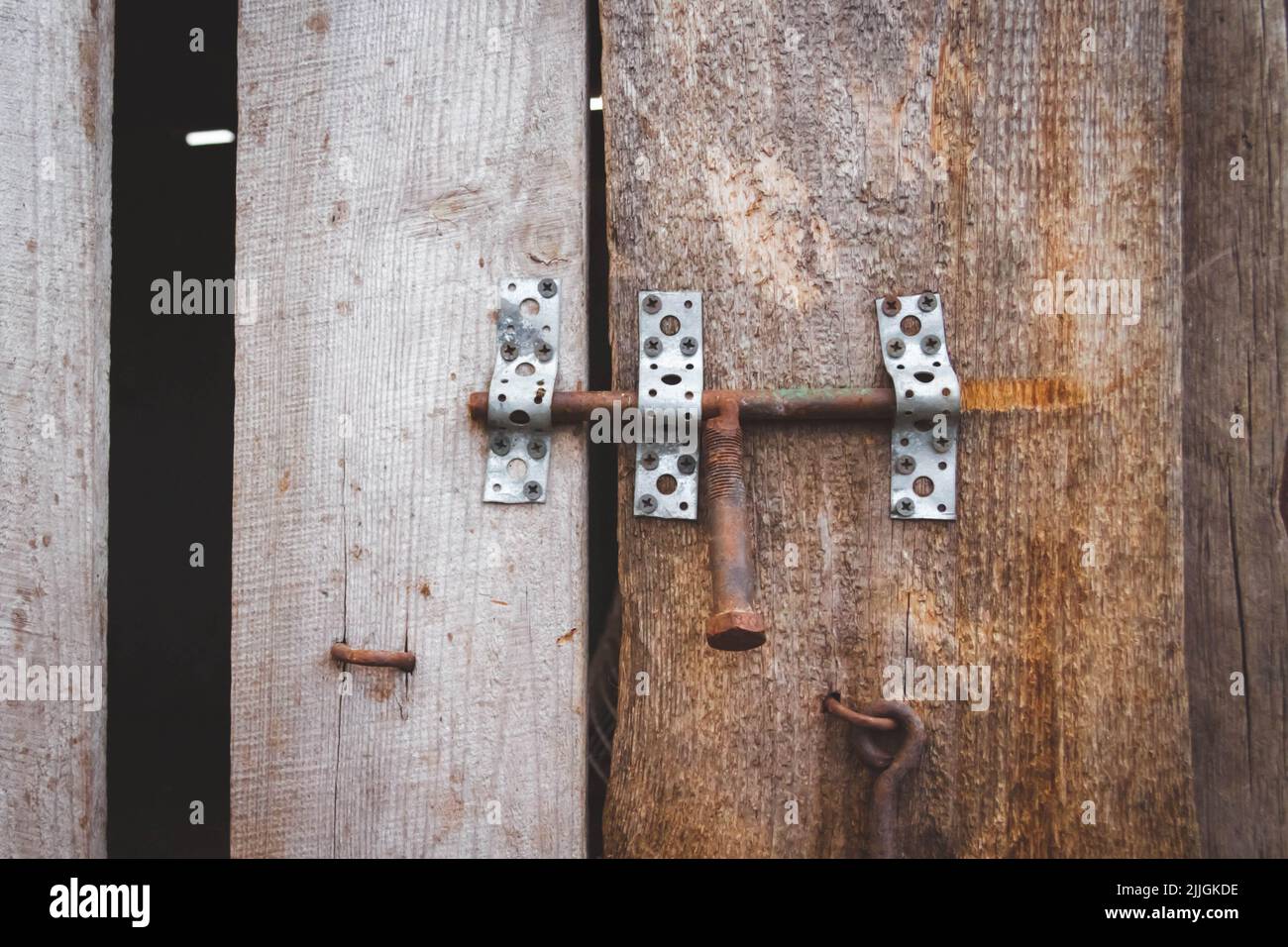 Vecchio bullone. Castello d'epoca. Porta su un gancio. Vecchia recinzione in legno. Territorio chiuso. Foto Stock