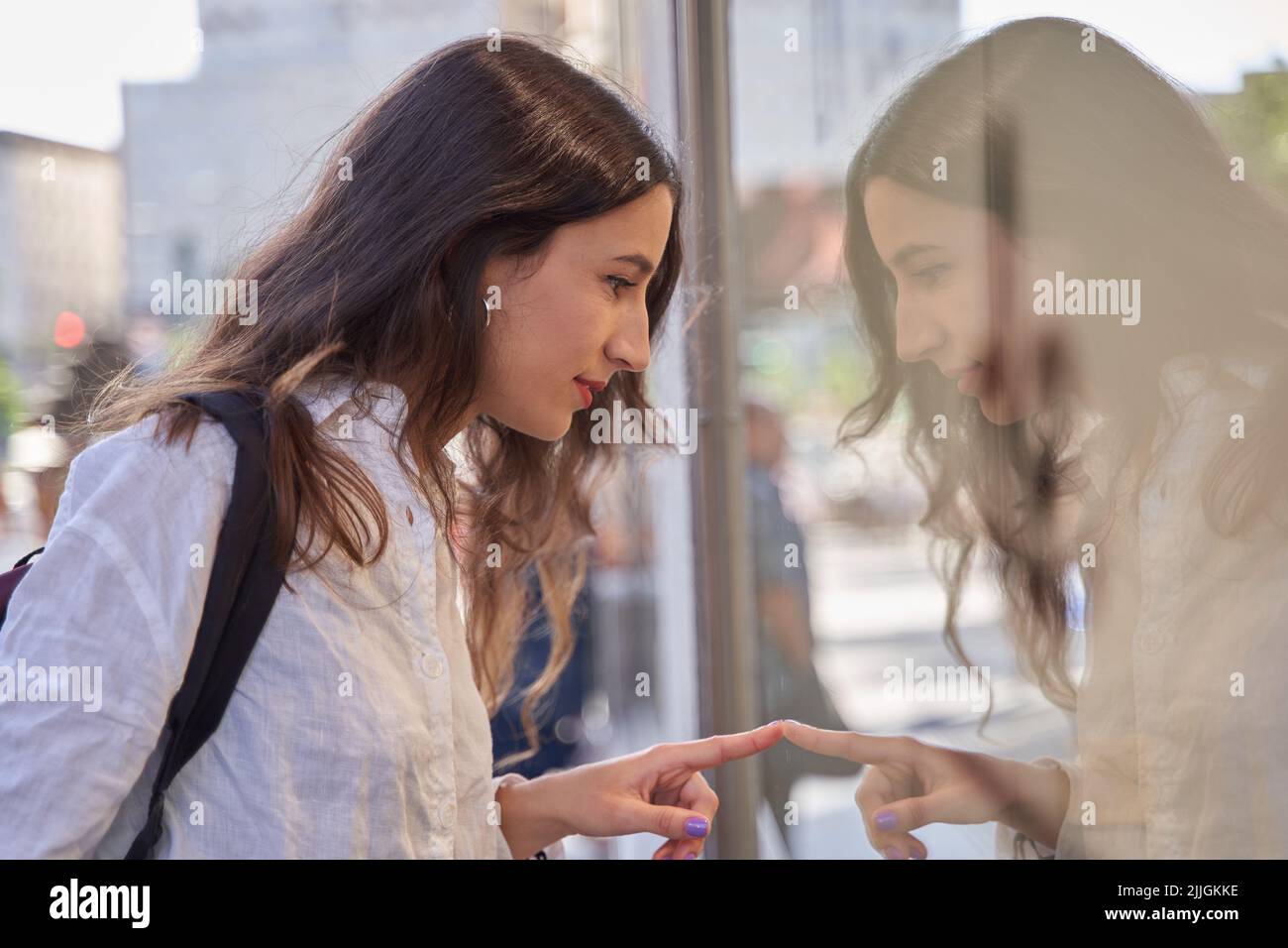 Primo piano ritratto di una giovane donna che guarda in una vetrina Foto Stock