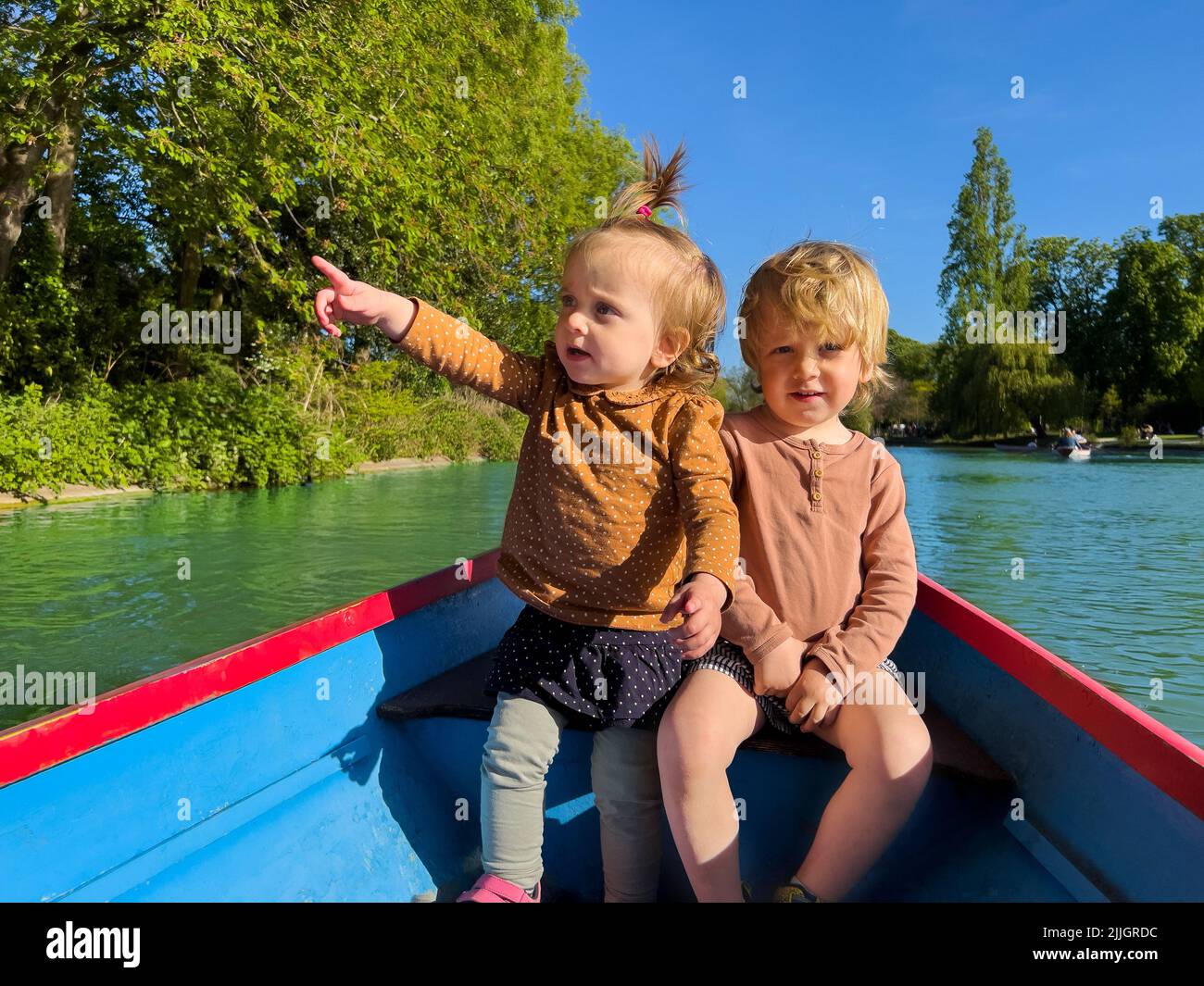 Due bambini piccoli di charme nella piccola barca laghetto paddle Foto Stock