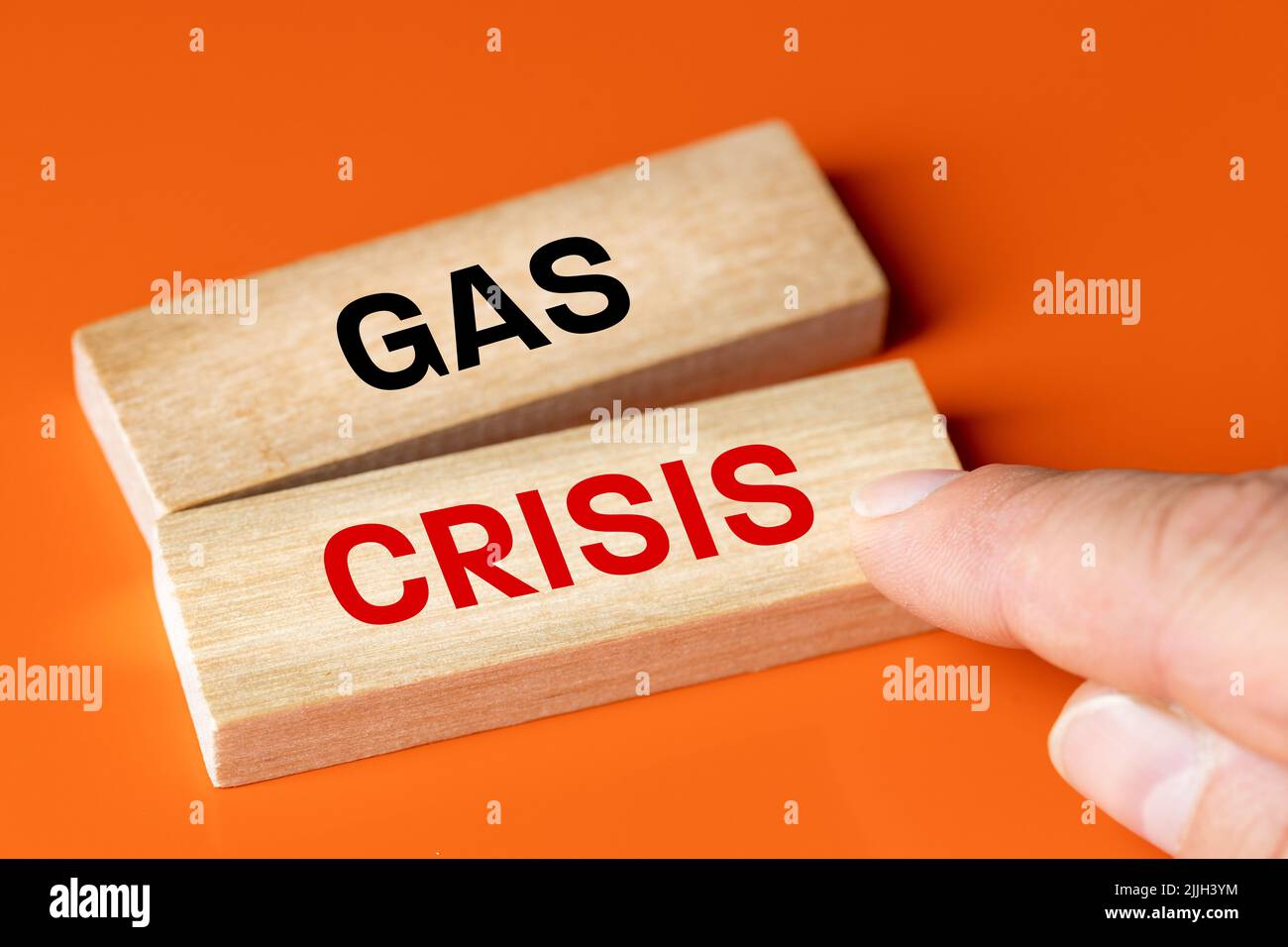 Crisi del gas, testo che mostra le dita su un blocco di legno, sfondo arancione, concetto della crisi energetica europea e la necessità di ridurre i consumi Foto Stock
