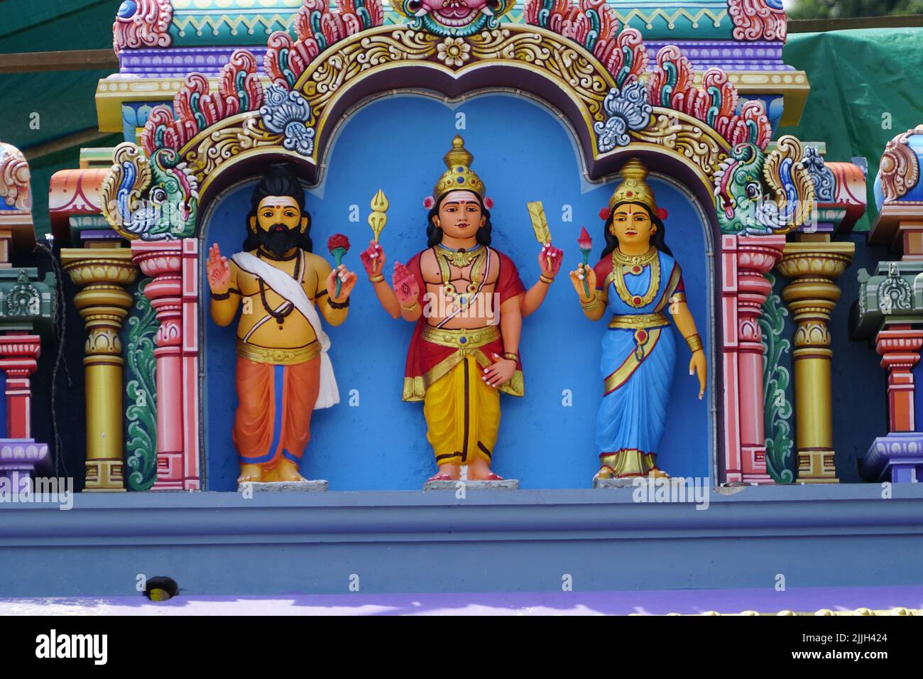 Le colorate statue di colorate figure della divinità indù su una parete del tempio in Malesia Foto Stock