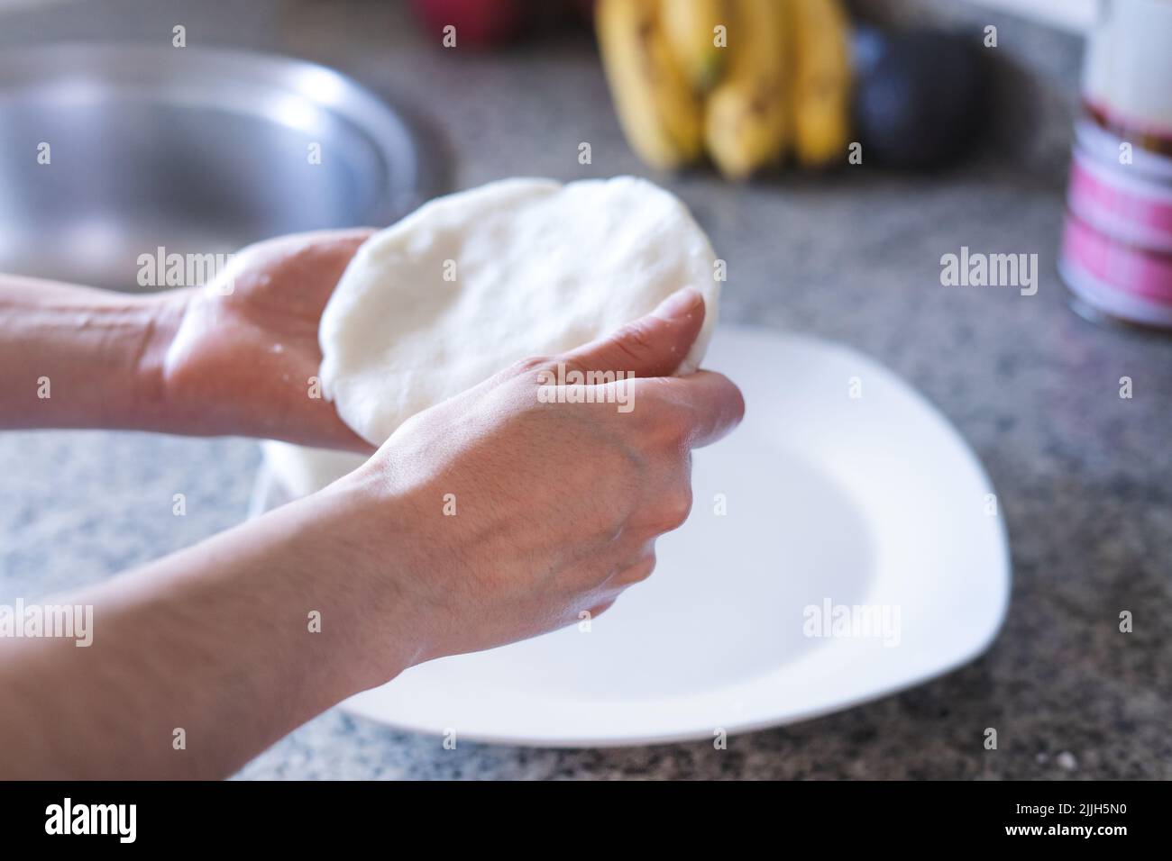 Donna mani che fanno arepas in cucina. Cibo latino. Foto Stock