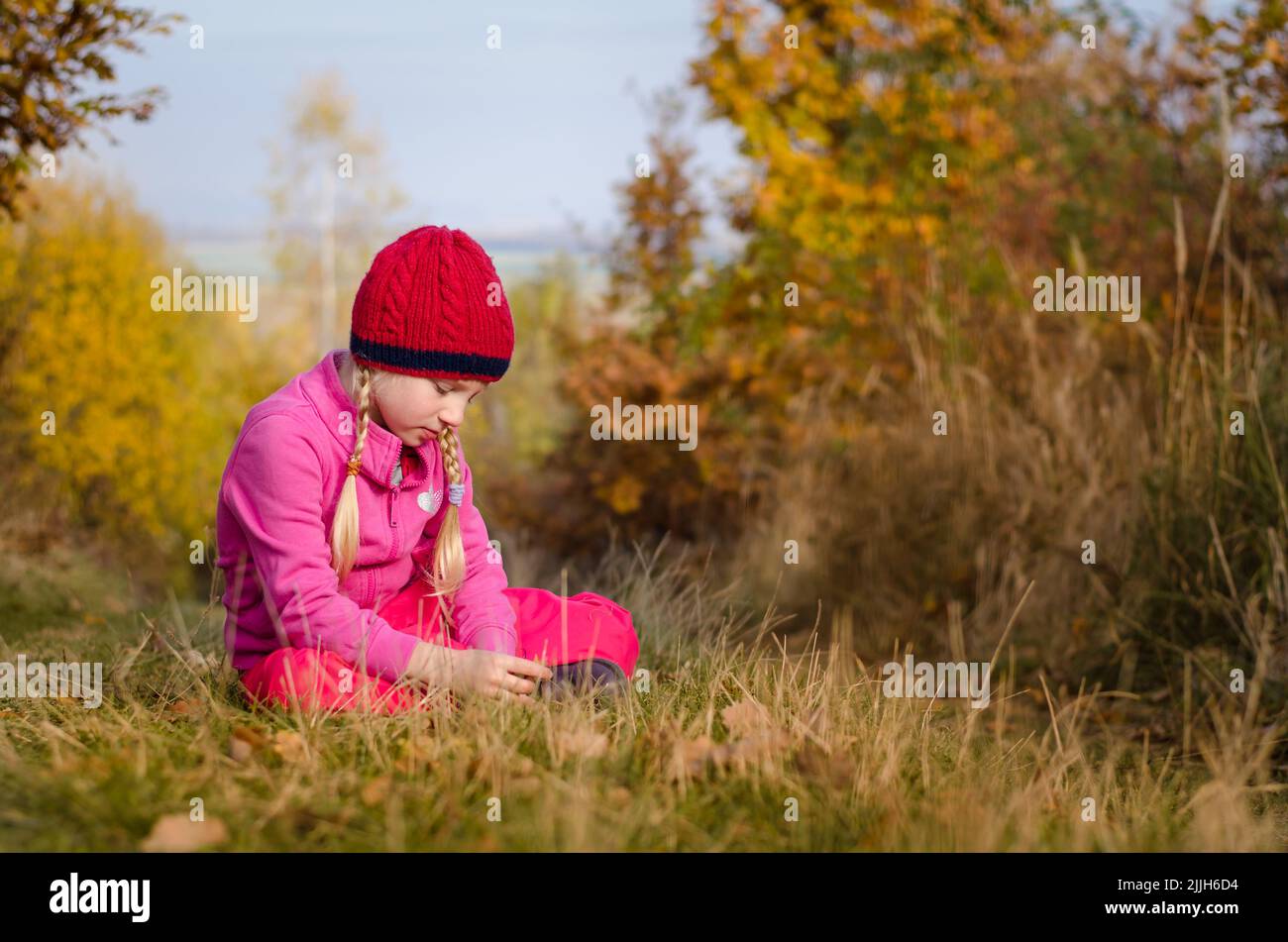 atmosfera d'autunno con primo piano di relax del bambino in un prato magico Foto Stock