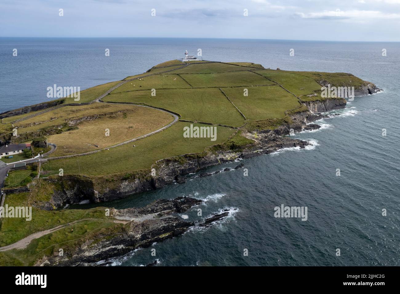 Drone scenario aereo di testa di galea con faro e campo verde in sughero conte Irlanda occidentale. Fari irlandesi Foto Stock