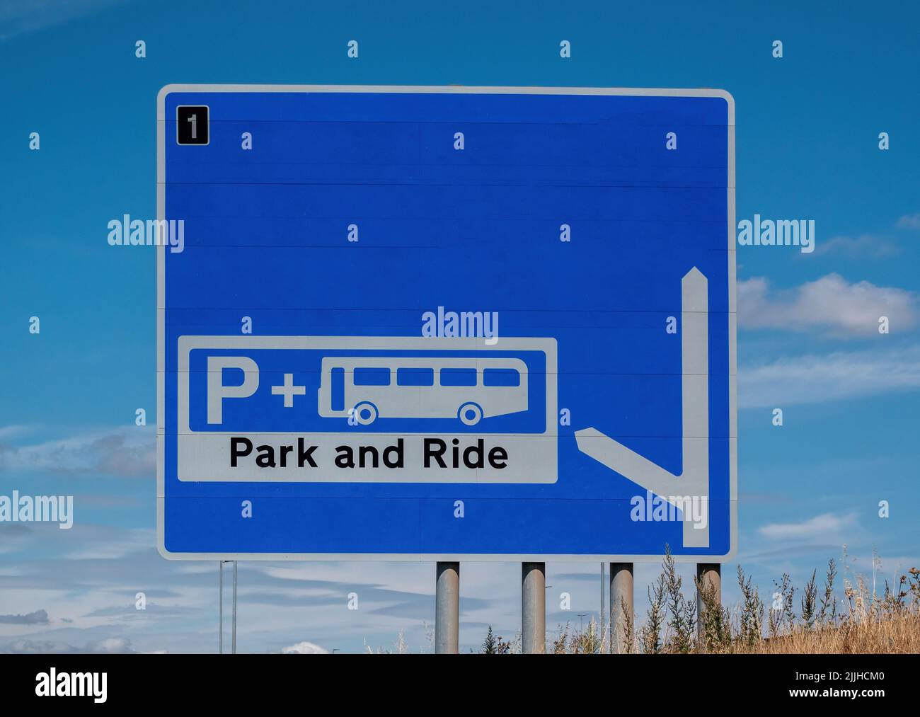 Un cartello autostradale britannico che indica un parco e una posizione di corsa al prossimo incrocio Foto Stock