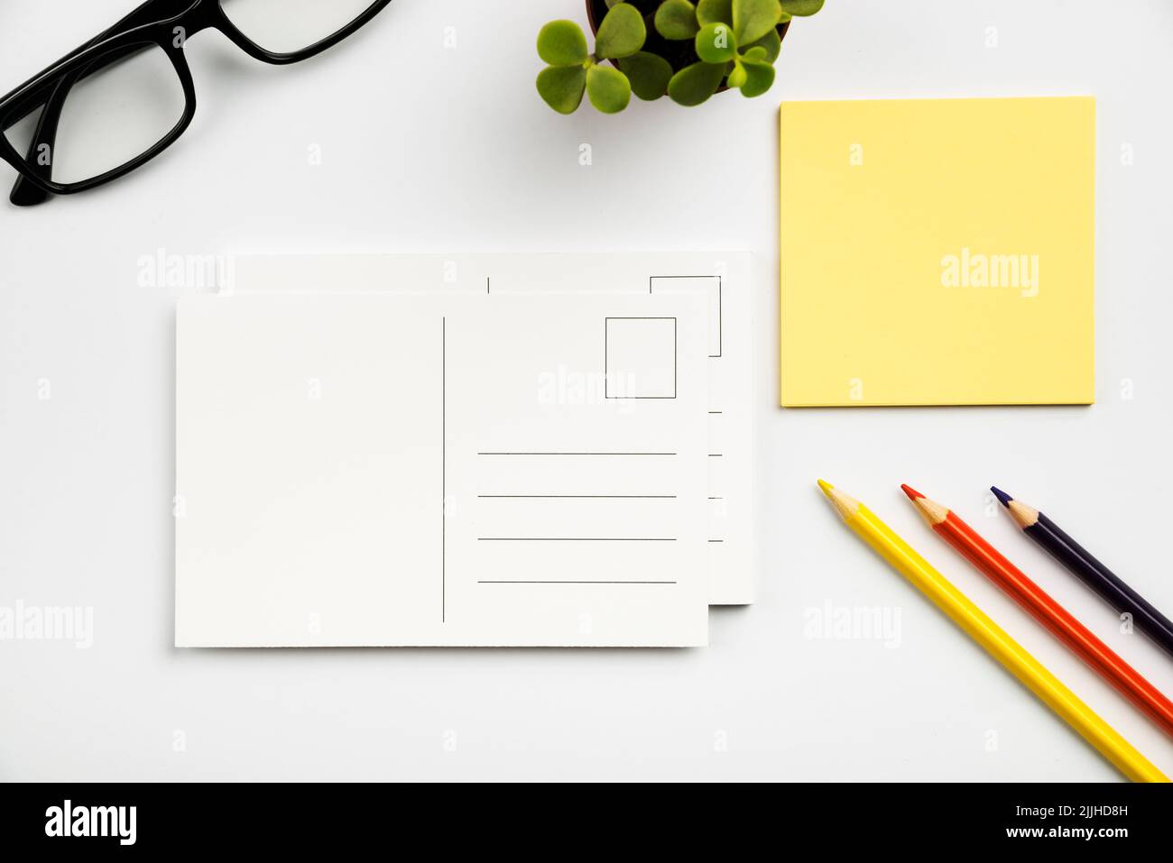Una vista dall'alto di un'area di lavoro ordinata con note adesive, matite e cartoline Foto Stock