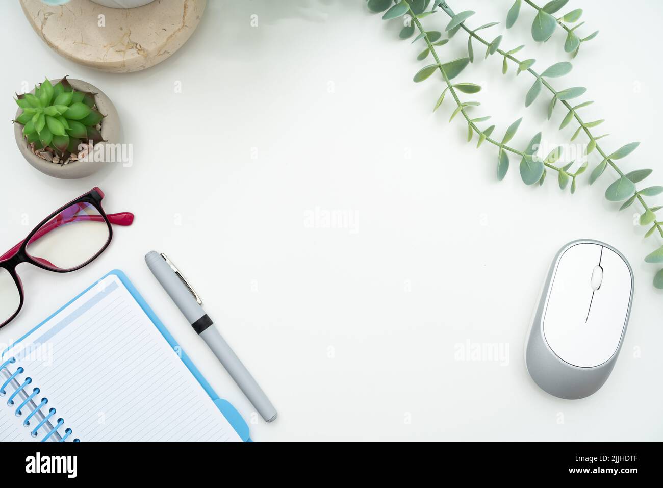 Vista dall'alto di un'area di lavoro ordinata con un notebook, una penna, occhiali e un mouse per computer Foto Stock