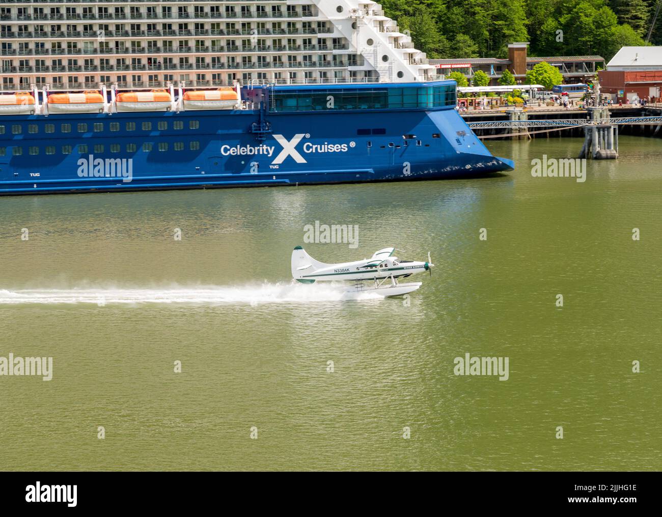 Juneau, AK - 9 giugno 2022: Decollo dell'idrovolante Wings Air a fianco della nave da crociera Celebrity Eclipse Foto Stock
