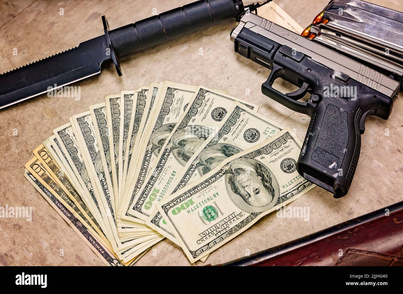 Armi e contanti sono esposti in una sala di prova del dipartimento di polizia dopo un busto di droga, il 3 febbraio 2012, a Columbus, Mississippi. Foto Stock