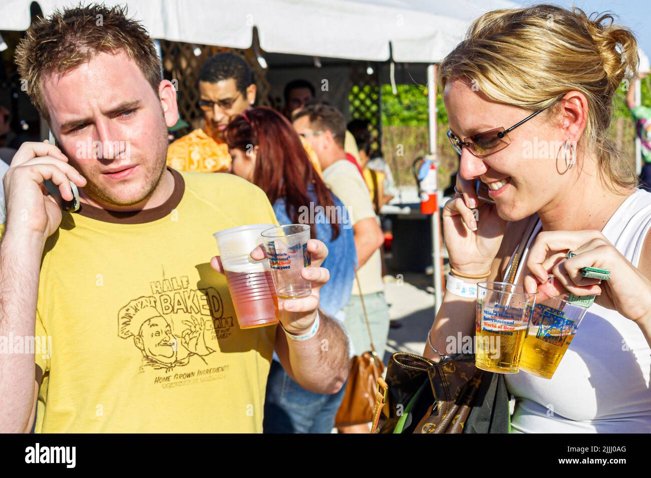 Miami Beach Florida, International Beer Festival, uomo donna coppia parlare telefoni cellulari Foto Stock