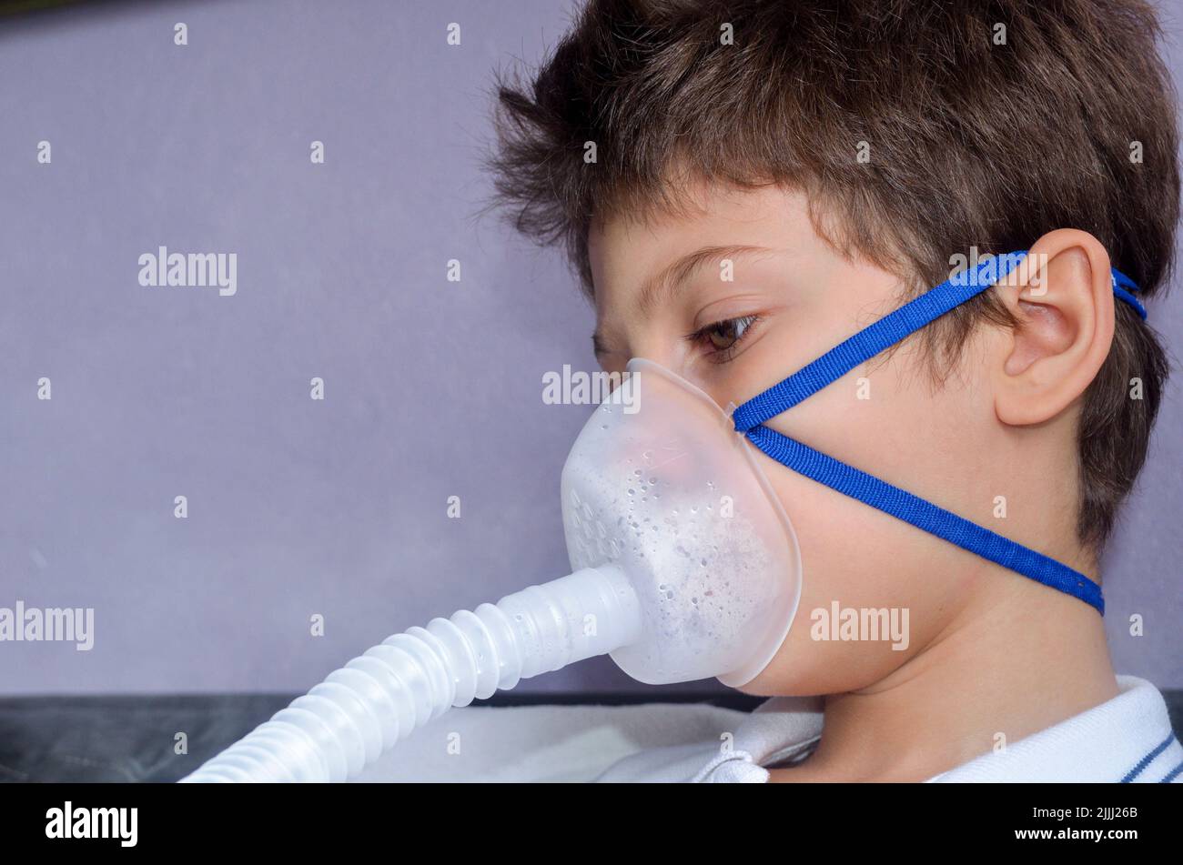 Bambino con maschera di appannamento sul suo viso gioco. Salvador, Bahia, Brasile. Foto Stock