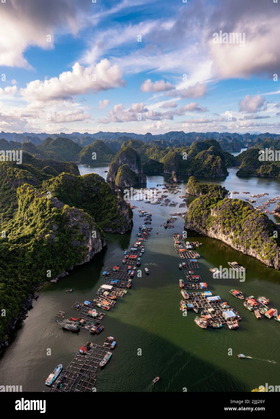 Villaggio galleggiante di pescatori e isola rocciosa nella baia di ' LAN ha ', Vietnam, Asia sud-orientale. Sito patrimonio dell'umanità dell'UNESCO. Orizzontale. Punto di riferimento popolare, famoso d Foto Stock