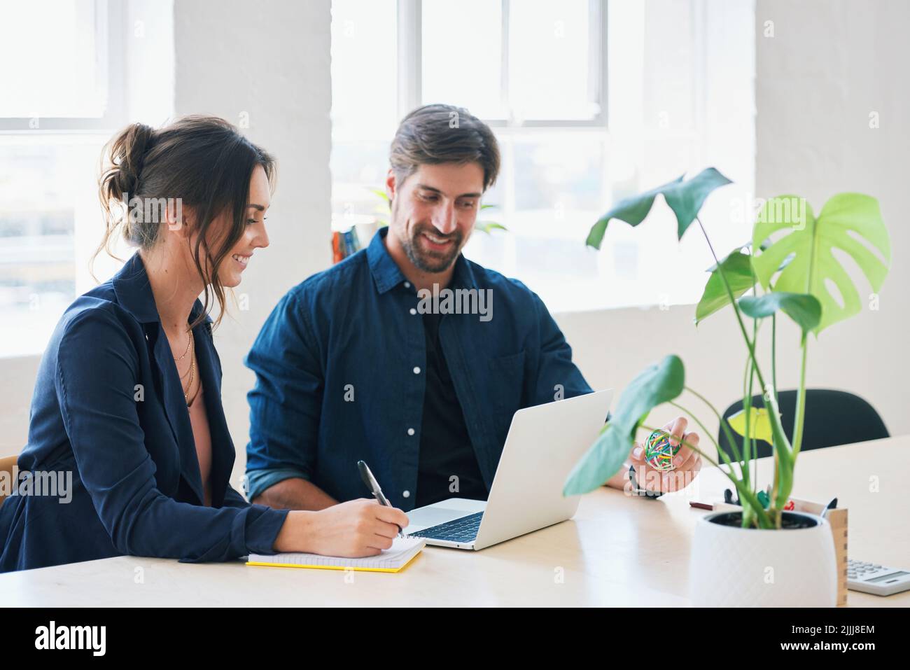 Due uomini d'affari che utilizzano computer portatili colleghi che lavorano in ufficio condividendo idee Foto Stock