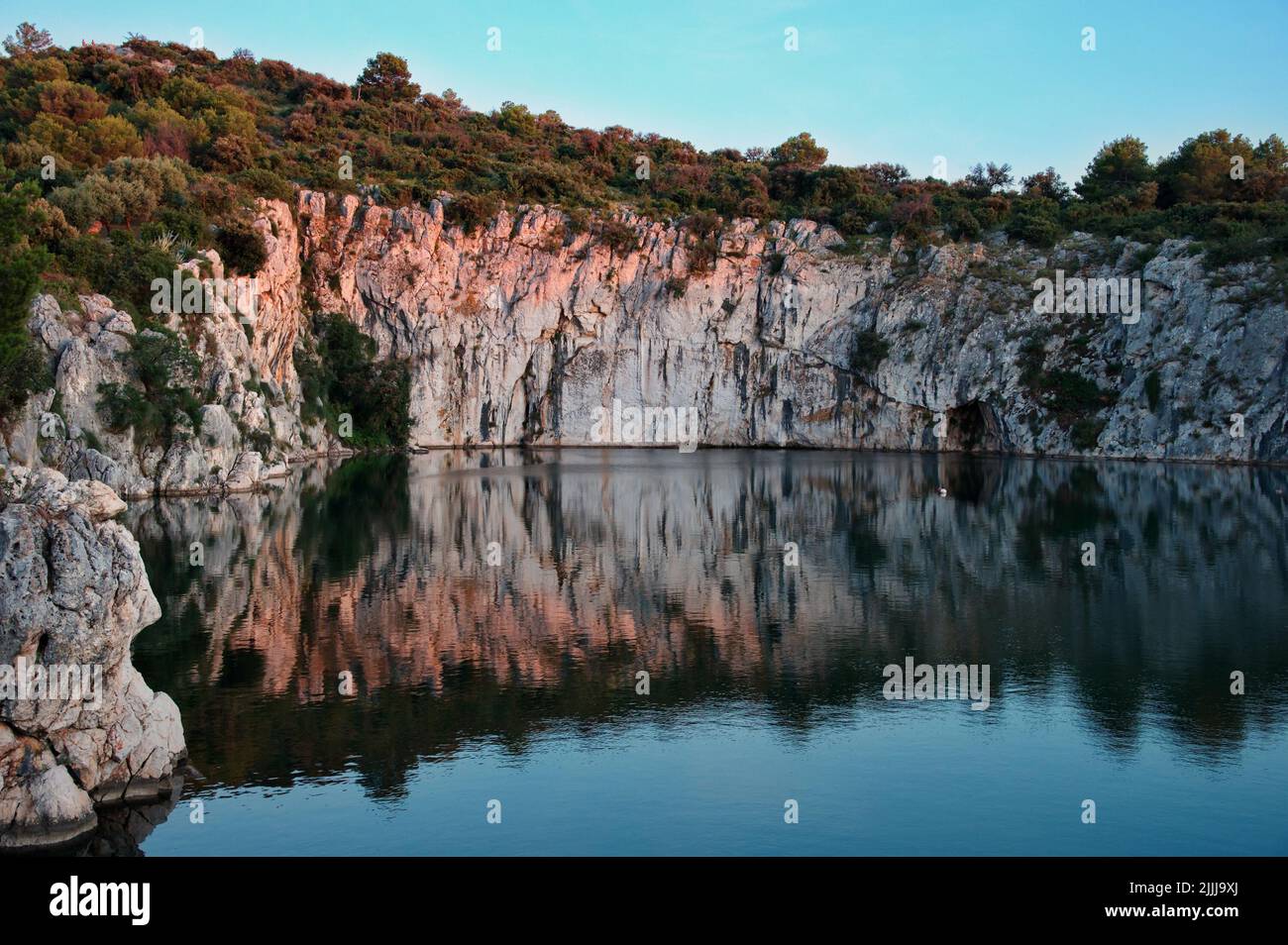La formazione rocciosa si riflette nell'acqua del lago Foto Stock