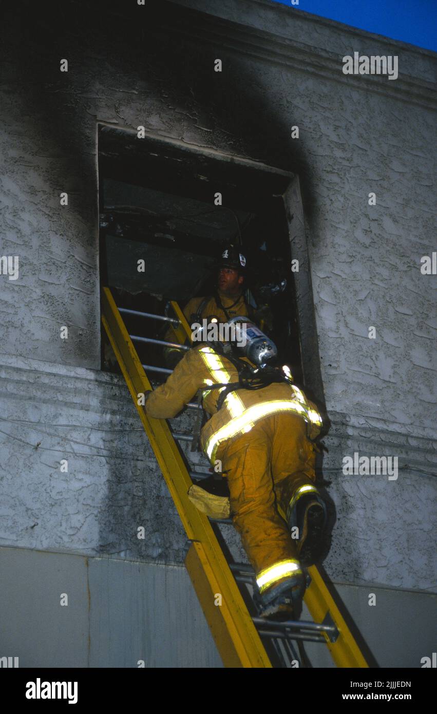 San Diego City (SDFD) scale pompieri al secondo piano di una struttura di fuoco Foto Stock