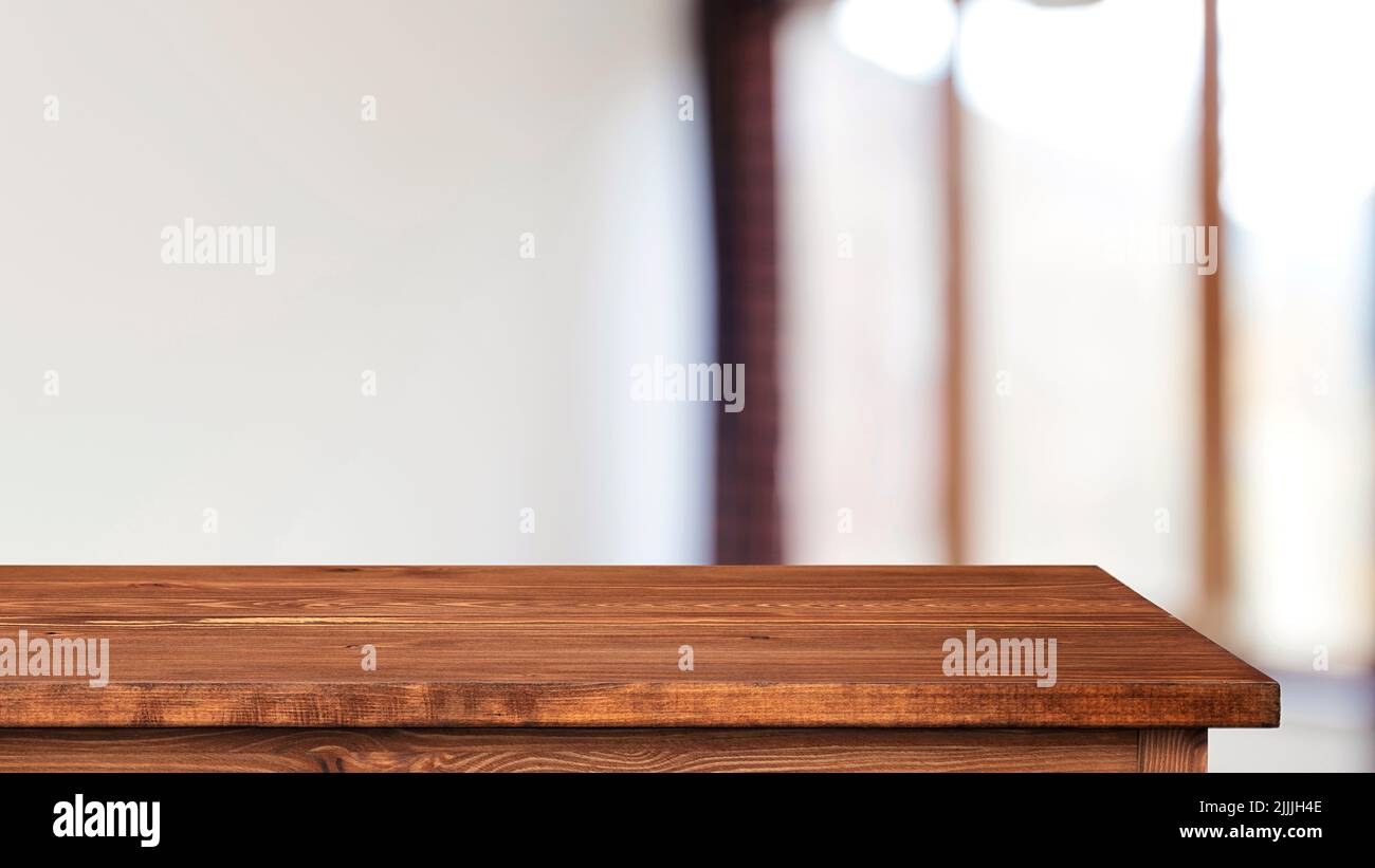 Piano o tavolo in legno vuoto marrone e interno sfocato con finestra e luce Foto Stock