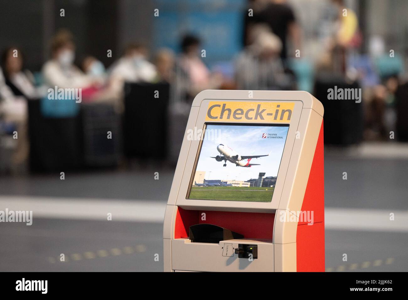 Dresda, Germania. 27th luglio 2022. I passeggeri delle compagnie aeree si siedono dietro un chiosco digitale per il check-in accanto ai loro bagagli all'aeroporto di Dresda. A causa dello sciopero di avvertimento di Verdi, Lufthansa ha annullato quasi l'intero orario di volo per mercoledì (27.07.2022). Credit: Sebastian Kahnert/dpa/Alamy Live News Foto Stock