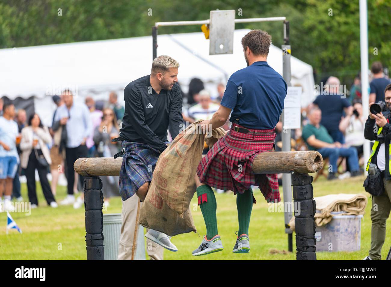 Le partite delle Highland si tengono a Tomintoul Moray il 17 luglio 2022, in Scozia, due uomini competono nel concorso di lotta a cuscino seduto su un palo in legno Foto Stock