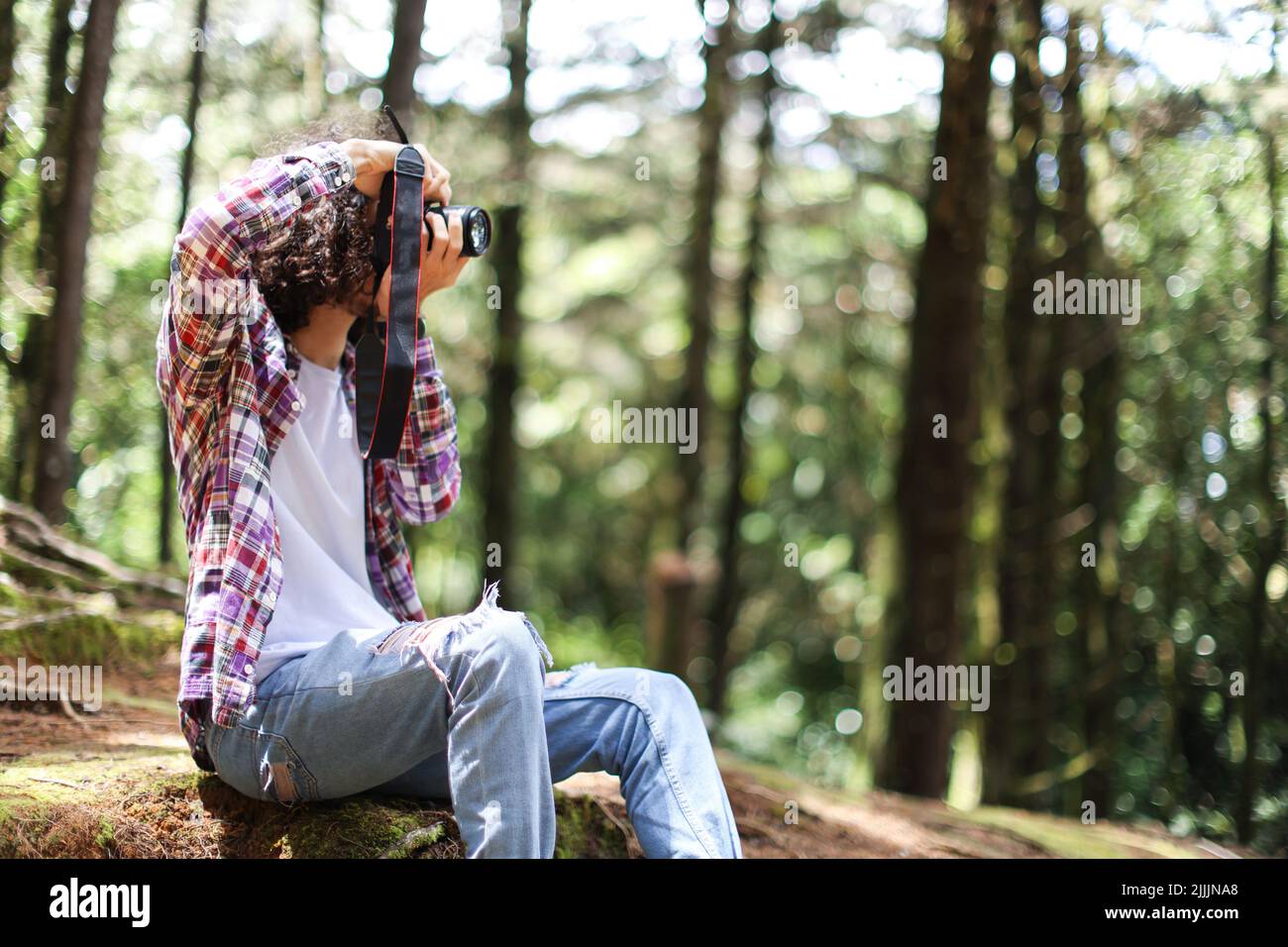 Fotografo senza volto scattando foto guardando proprio nella foresta tenendo fotocamera in Costa Rica Foto Stock