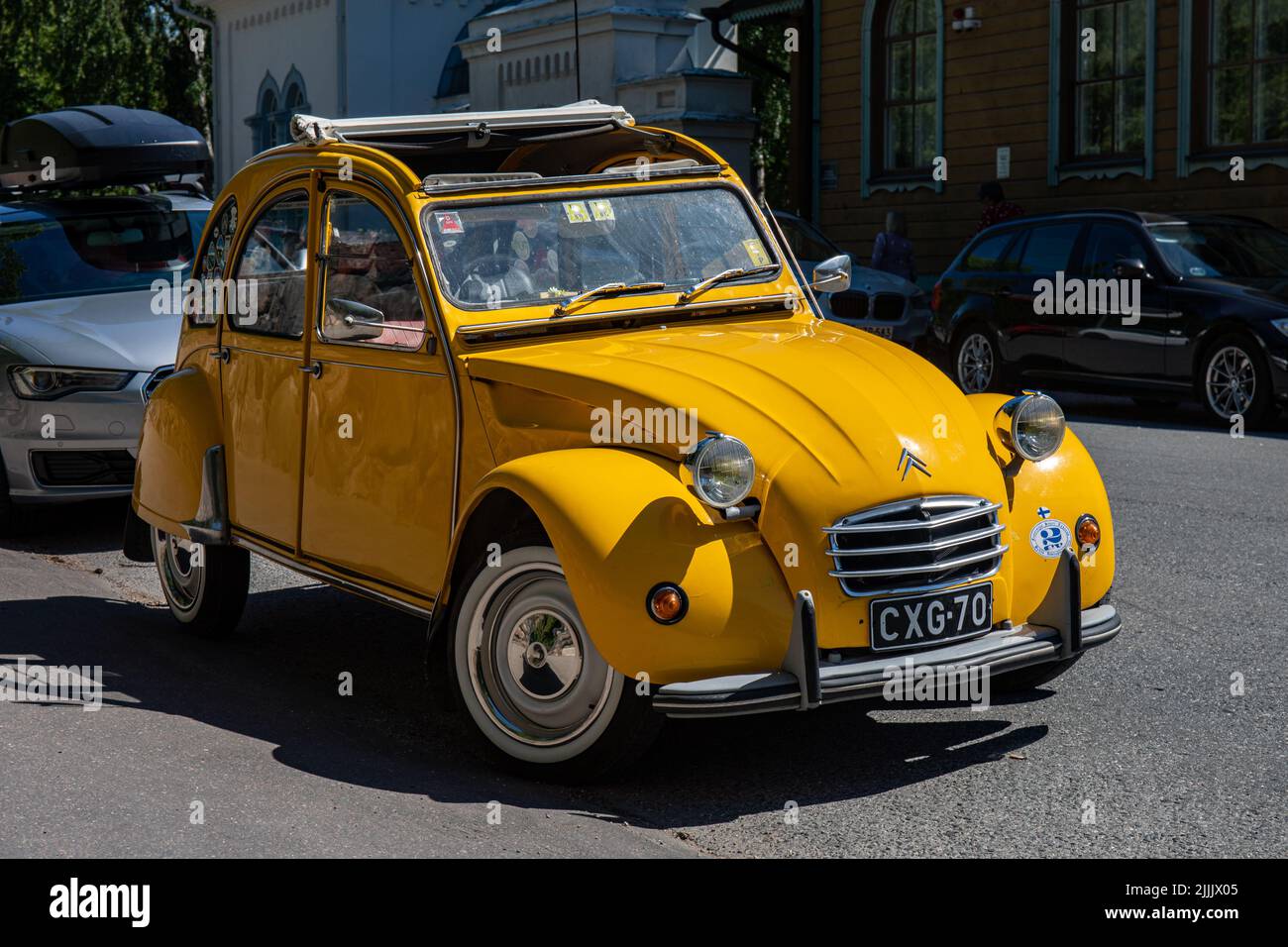 Vecchio giallo Citroën 2CV con tetto di tela arrotolata in Helslinki, Finlandia Foto Stock