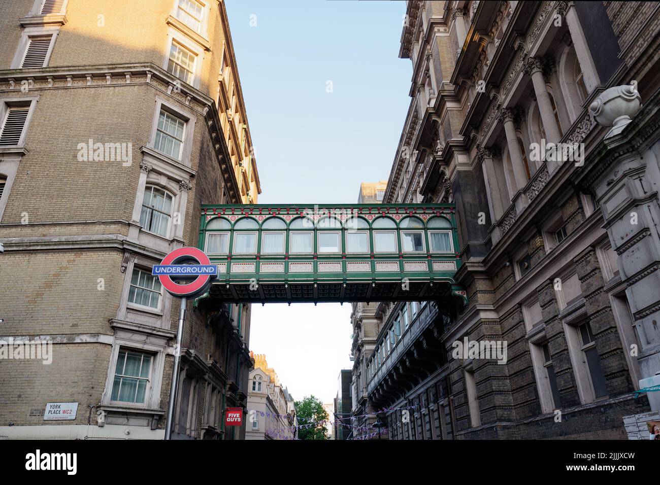 Londra, Greater London, Inghilterra, 22 2022 giugno: Villiers Street con un ponte ornato che collega l'edificio e un cartello della metropolitana. Foto Stock