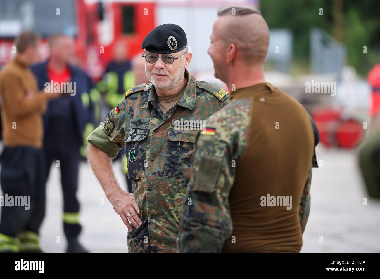 Falkenberg, Germania. 27th luglio 2022. Il generale Brigadier Jürgen Karl Uchtmann (l), comandante del comando regionale di Berlino, ringrazia i soldati coinvolti negli sforzi di estinzione degli incendi nel fuoco forestale. I vigili del fuoco di Brandeburgo continuano a combattere un importante incendio boschivo nel distretto di Elbe-Elster. Da lunedì (25,07.) brucia su una superficie di 800 ettari. Le aree sono parzialmente contaminate da munizioni. Questo complica il lavoro di estinzione degli incendi. Credit: Jan Woitas/dpa/Alamy Live News Foto Stock