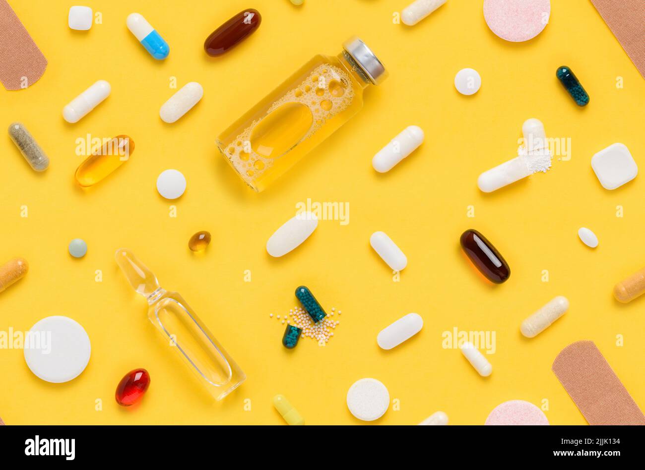 Modello senza cuciture di farmaci meciali compresse e pillole assortimento con flacone di vetro ampolla e fascetta di aiuto su sfondo giallo vista dall'alto piatto Foto Stock
