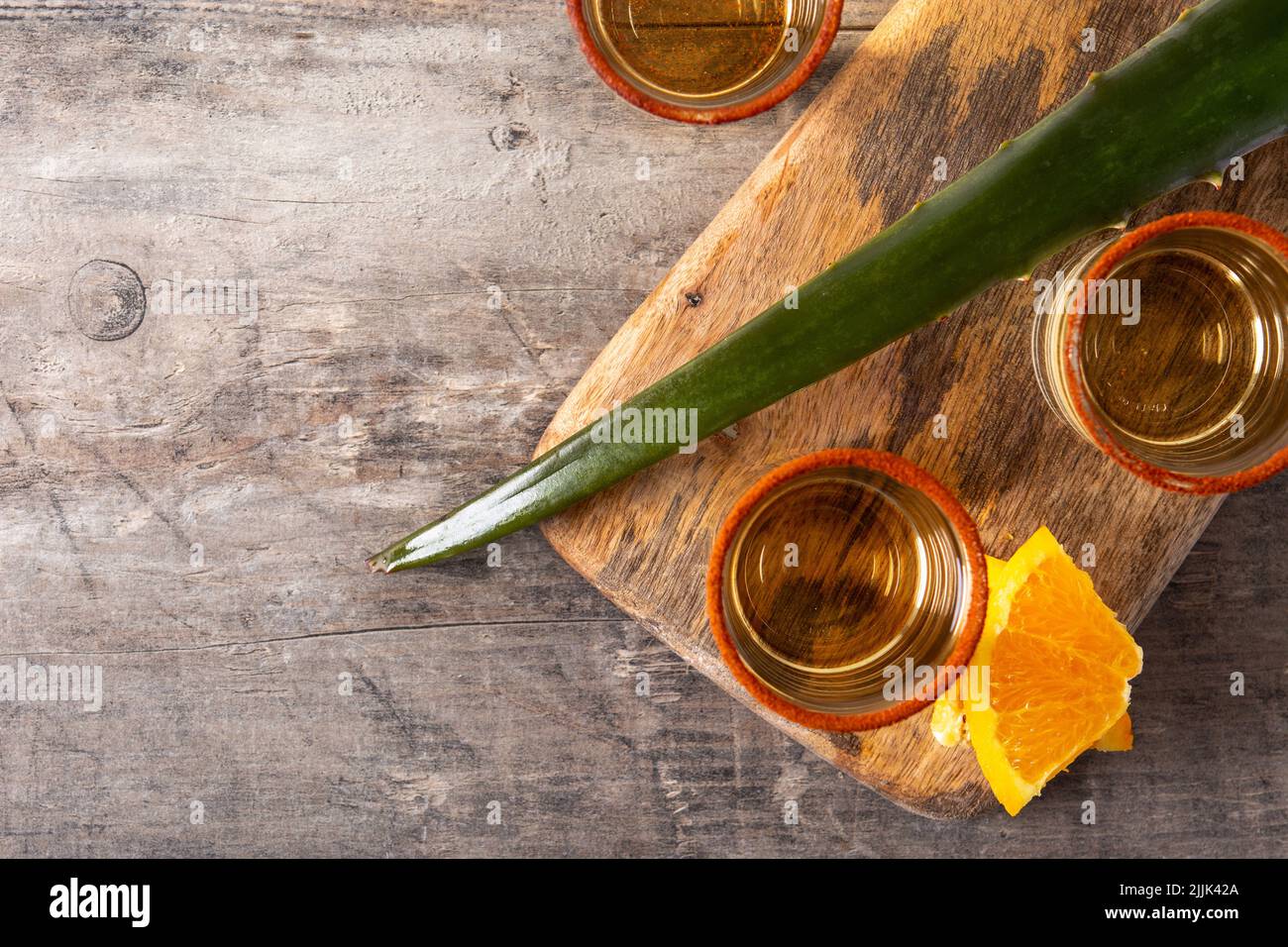 Mezcal bevanda messicana con fette d'arancia e sale di verme su tavola di legno Foto Stock