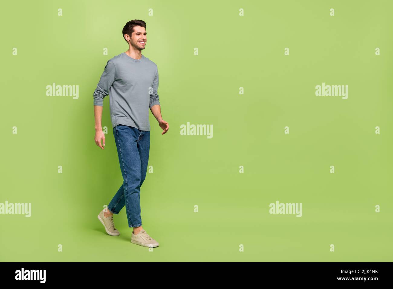 Immagine laterale del profilo a dimensione intera di allegro bell'uomo shopaholic visita centro commerciale isolato su sfondo di colore verde Foto Stock