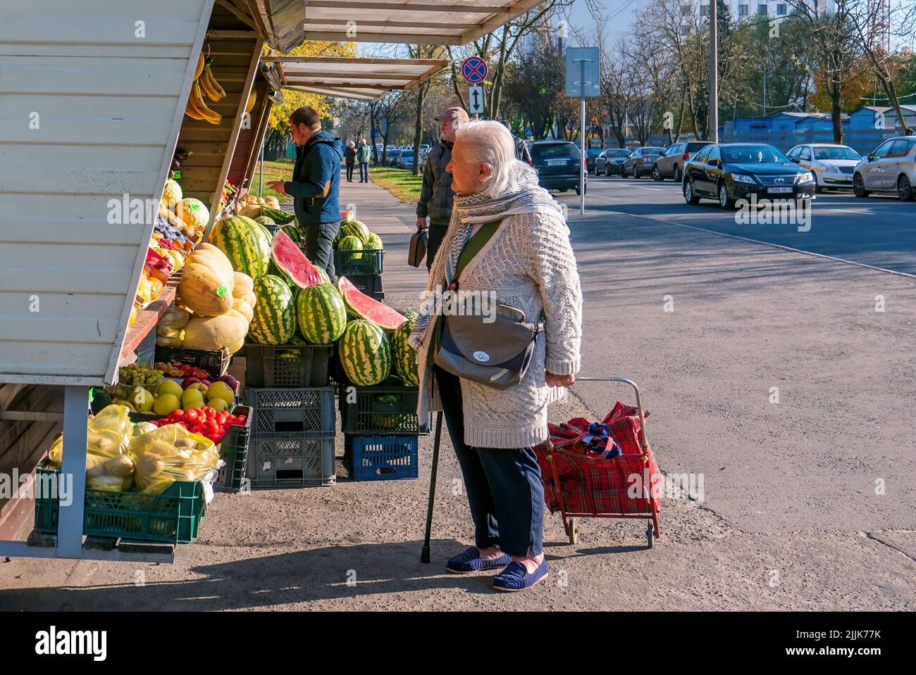 Minsk, Bielorussia - 09 ottobre 2018: Una donna molto anziana guarda le bancarelle di frutta. Il concetto di difficoltà finanziarie nella vecchiaia Foto Stock