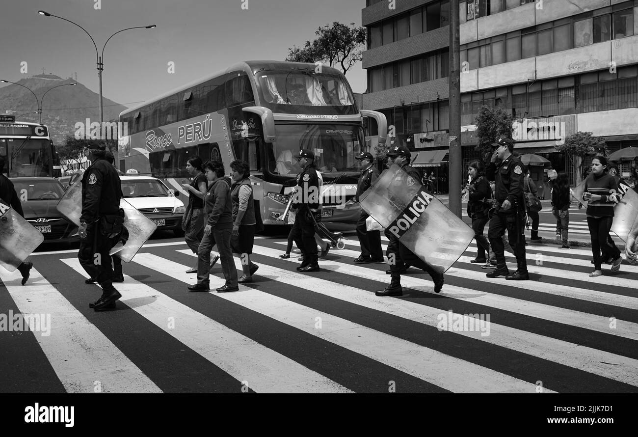 Un primo piano di polizia che attraversa la strada verso una protesta a Lima, Perù Foto Stock