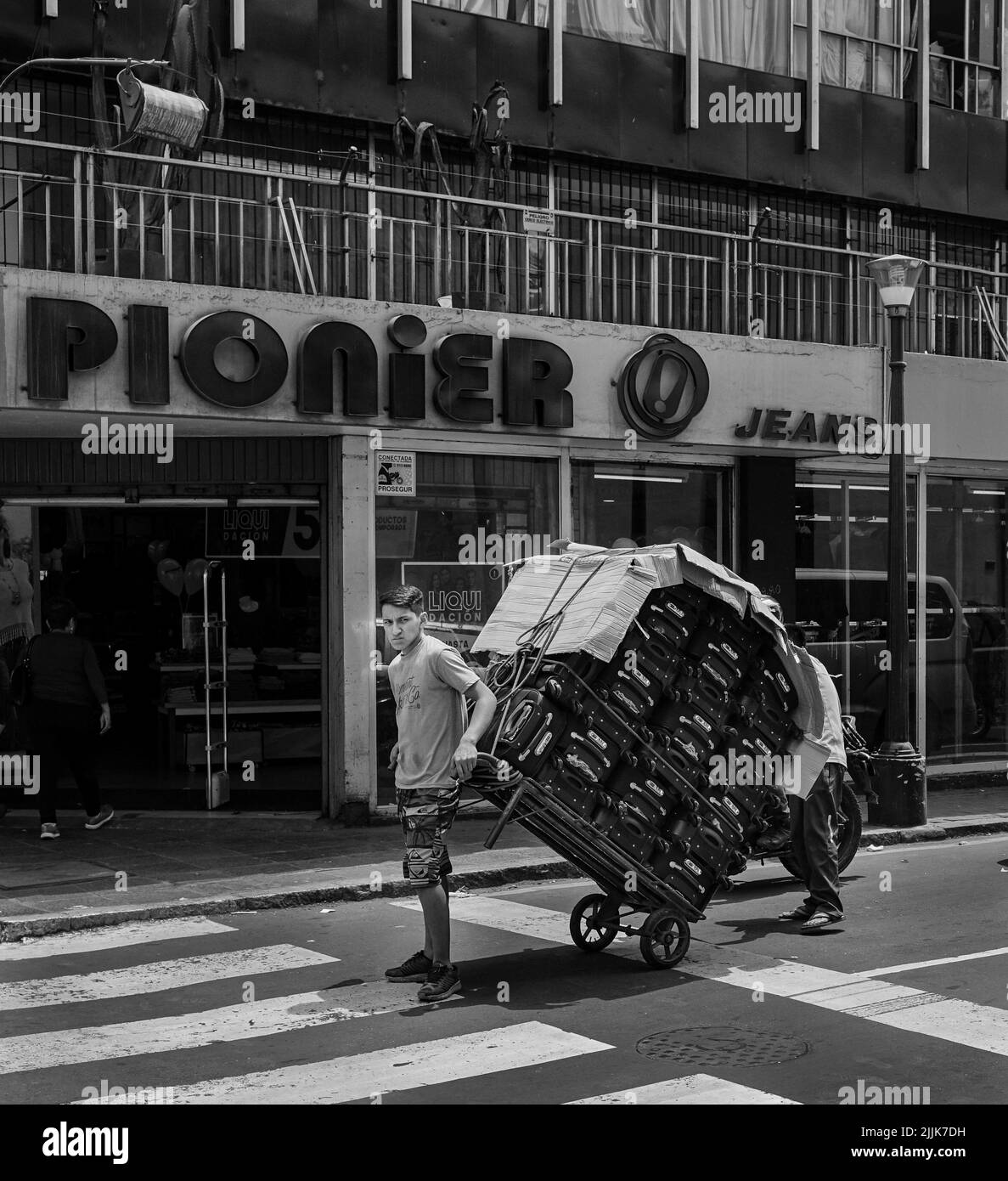 Un primo piano di una valigia di un giovane uomo duro-lavoro cart attraverso le strade di Lima, Perù Foto Stock