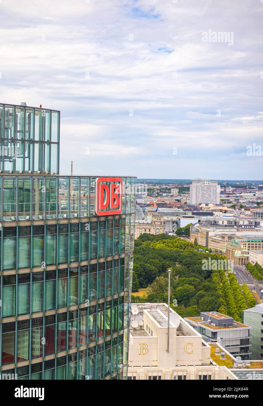 Berlino, Germania - 29 giugno 2022: Il logo Deutsche Bahn in cima alla Bahntower, sede della ferrovia tedesca. Lo skyline di Berliner sullo sfondo Foto Stock