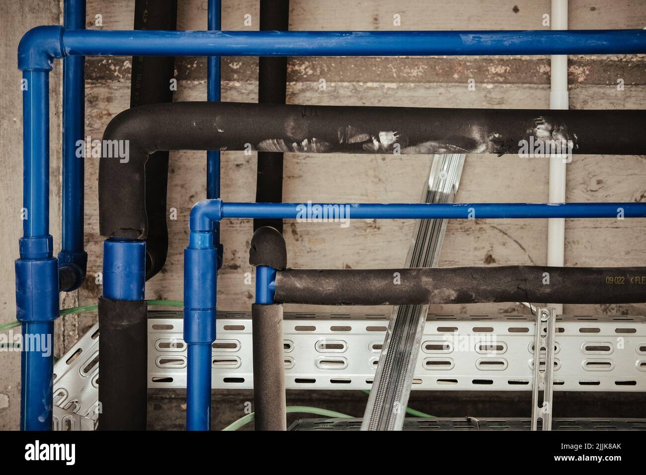 Un primo piano di tubi neri e blu in un edificio Foto Stock