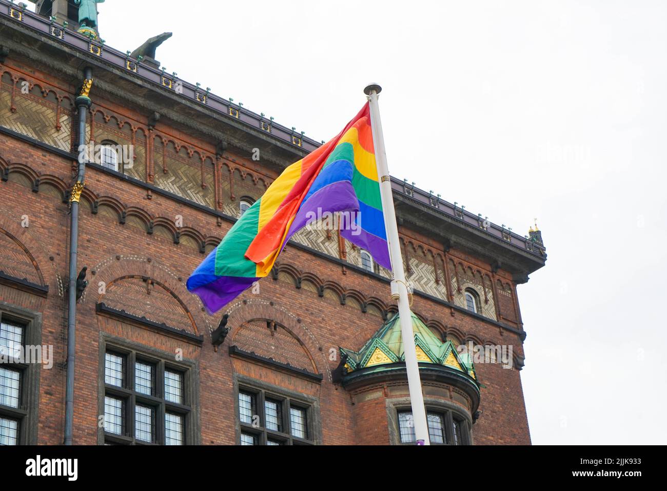 La bandiera di orgoglio vicino ad un edificio nelle strade di Copenhagen Foto Stock