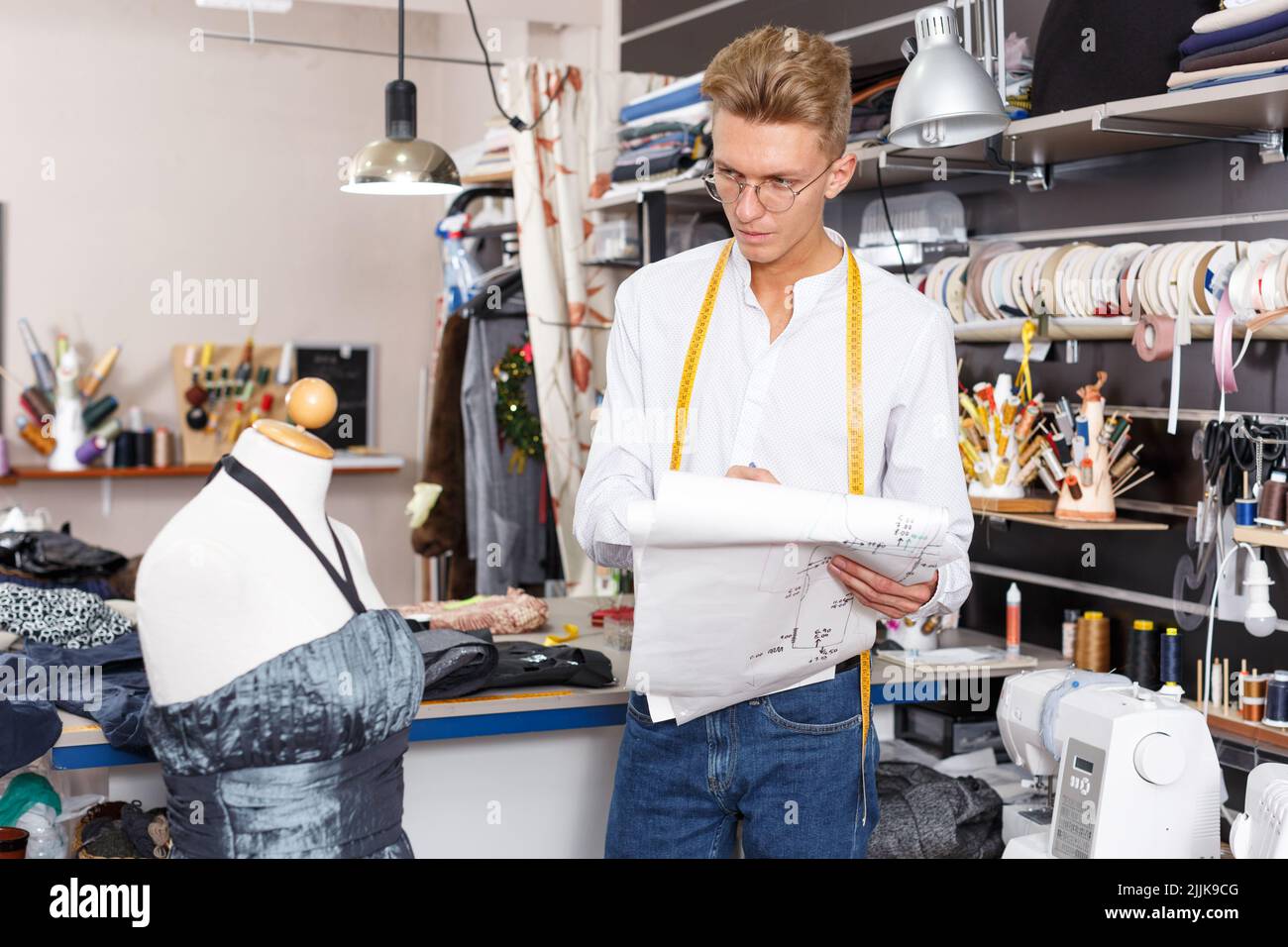 Stilista di moda in piedi vicino a manichino su misura Foto Stock